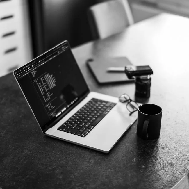 Hands typing on a laptop showing an e-commerce website in a modern office setting.